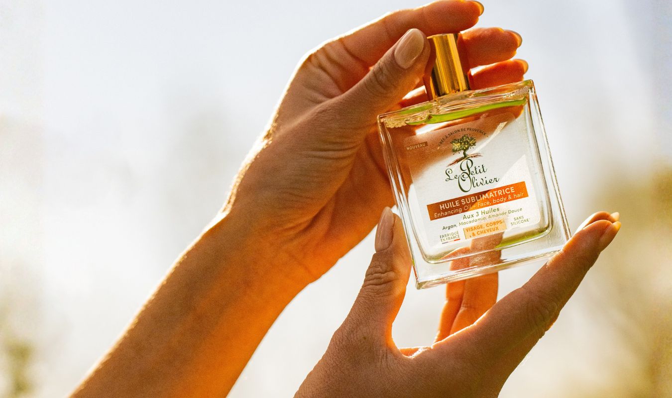 bouteille d'huile d'argan tenue entre les mains